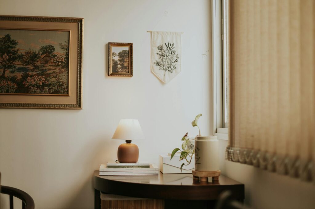 A parlor palm in a matte ceramic planter beside a sofa in a small apartment living room.
